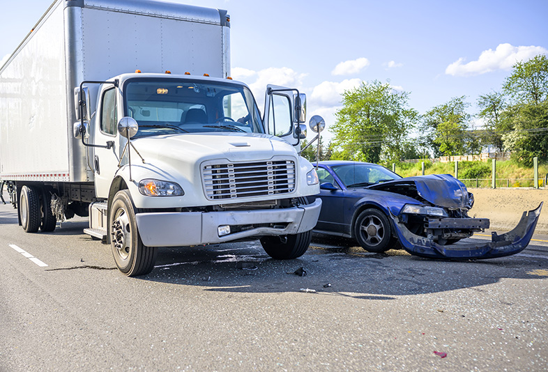 Semi-truck next to a car it damaged in an accident