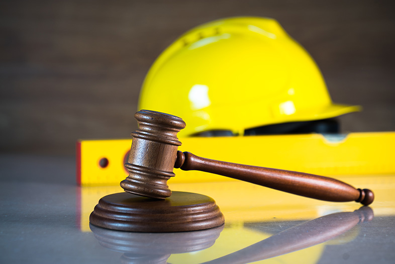 Gavel sitting in front of a construction cap