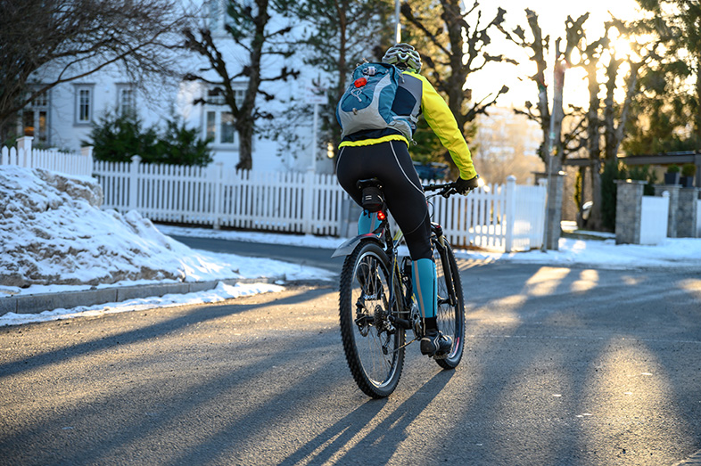 Winter cyclist riding with a helmet through suburban streets