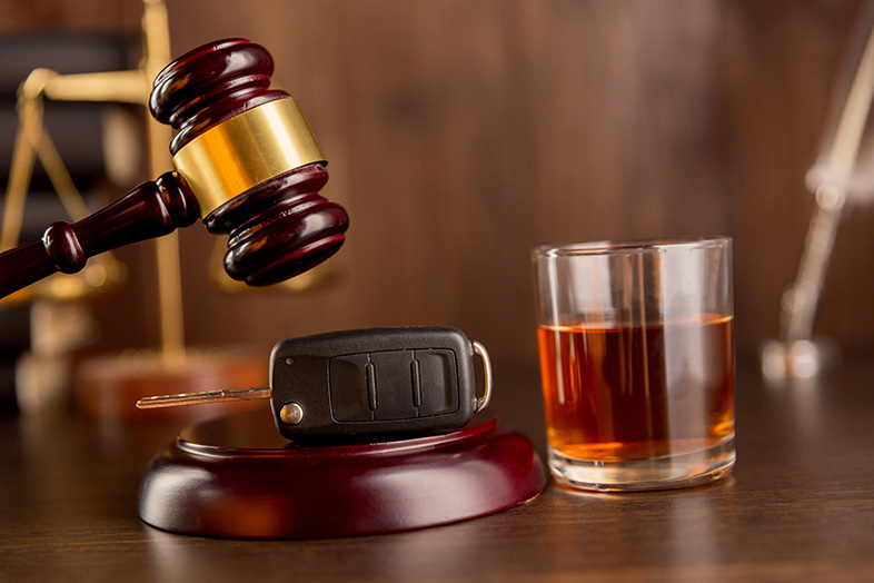 Drunk-driving concept, gavel with car keys by a glass of whiskey