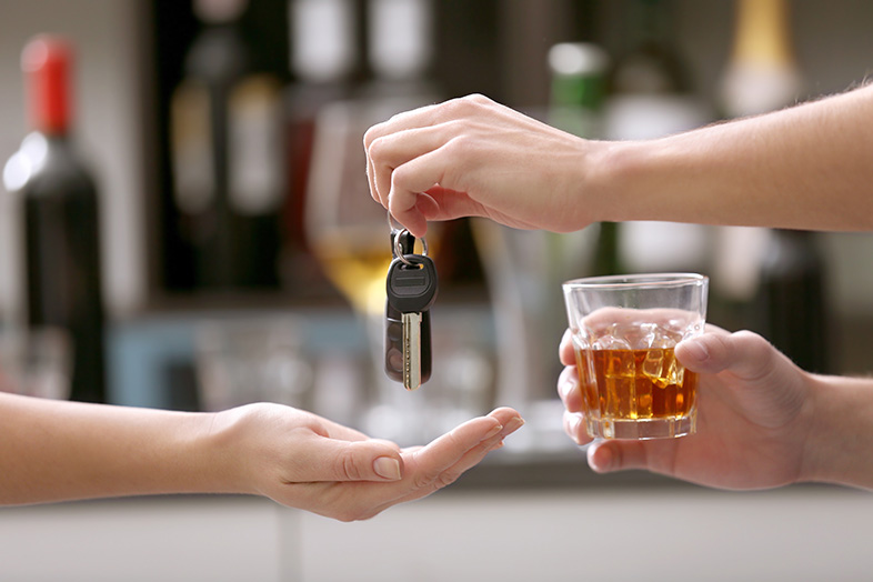Intoxicated man giving his car keys to a friend to prevent a drunk-driving accident
