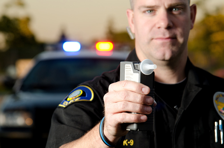 Wisconsin police officer holding breathalyzer to test a driver's blood alcohol content