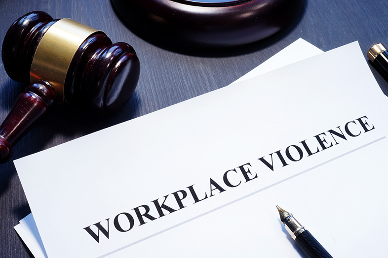 Document about workplace violence on a table next to a gavel
