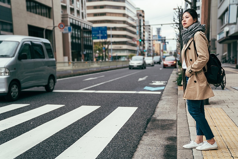 Woman looking both ways before crossing the street to avoid an auto-pedestrian accident