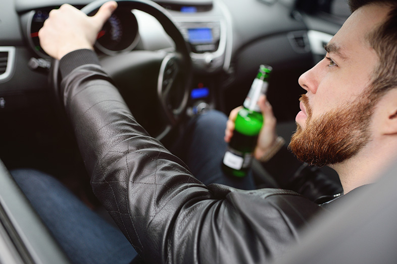 Man drinking from a bottle of beer while driving in Wisconsin