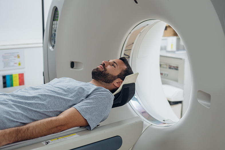 Accident victim lying on the CT scanner bed before having an MRI to diagnose a TBI