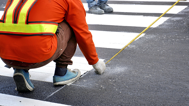 Road worker making lines for a new pedestrian crosswalk in Winnebago County