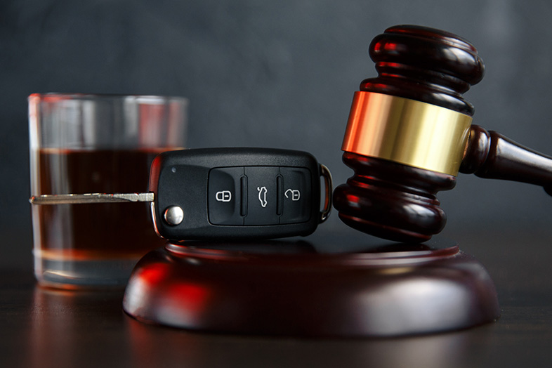 Car keys sitting on top of a gavel next to a glass of whiskey. New drunk-driving laws coming to Wisconsin