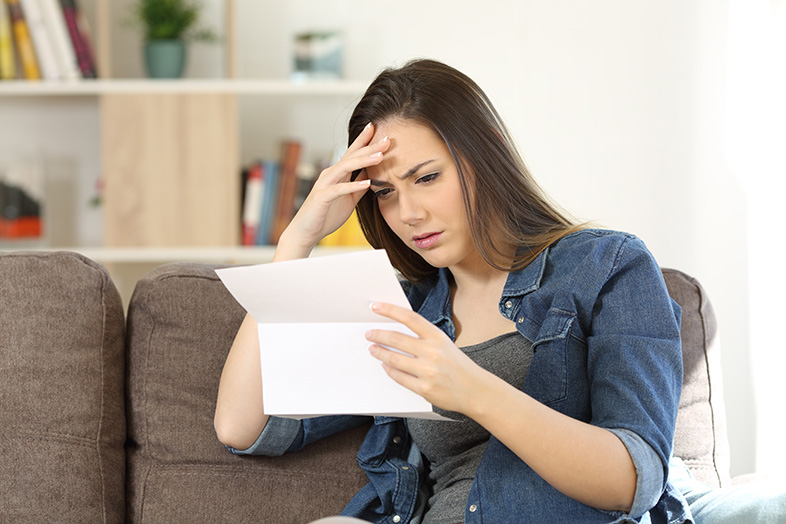 Injured employee reading her workers' compensation claim denial