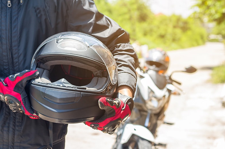 Motorcyclist holding his helmet before a ride
