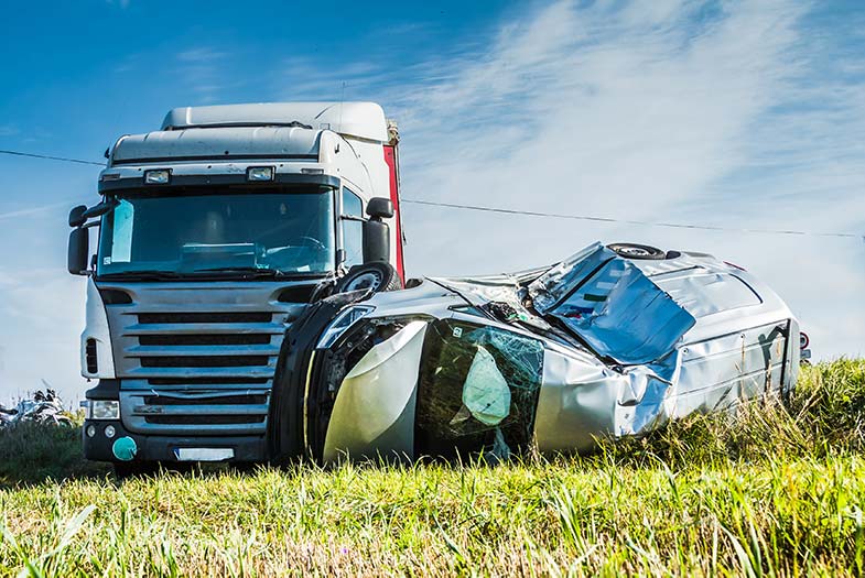 Semi-truck and seriously damaged car on the side of a Wisconsin road following an accident