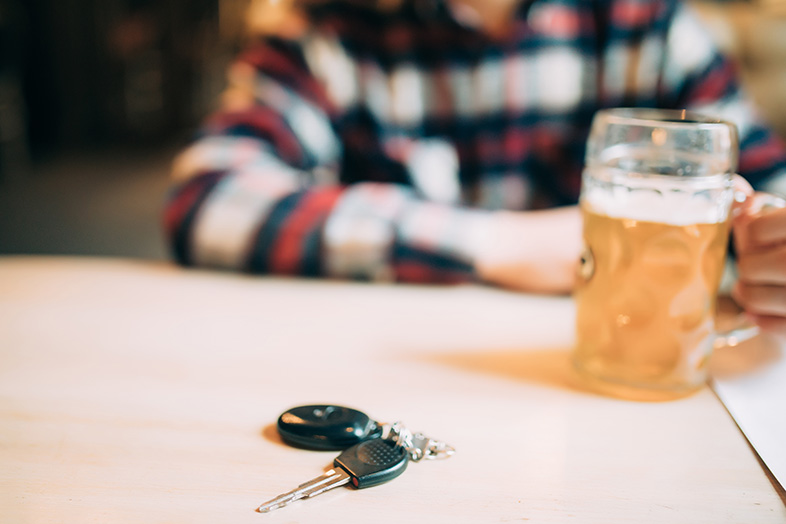Wisconsin man drinking a beer with his car keys on the table after deciding not to drive drunk