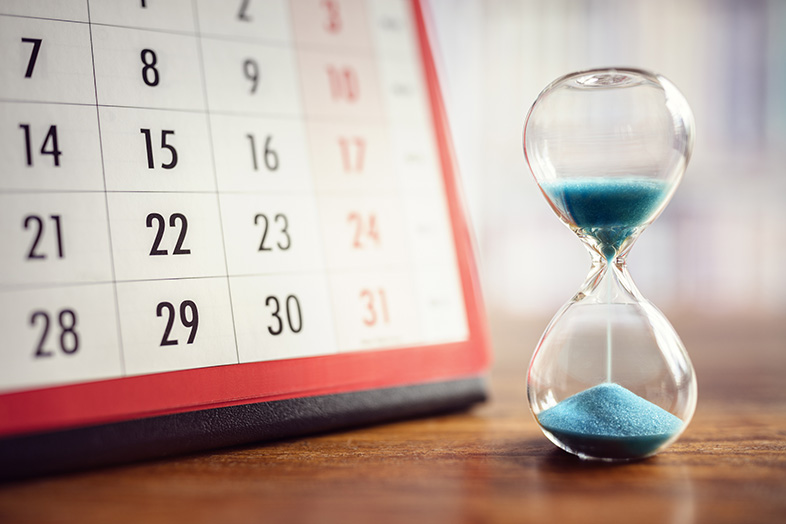 Hourglass in front of a calendar indicating the deadline for filing a wrongful death suit