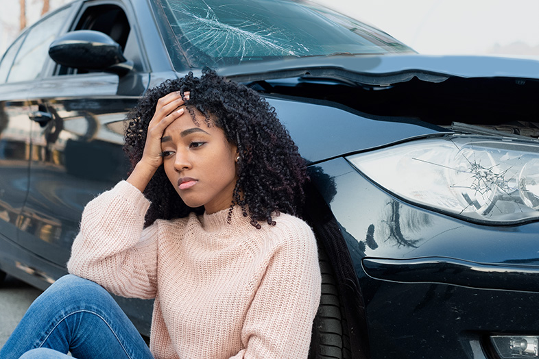 Wisconsin teen girl sitting next to her damaged car after causing a car accident
