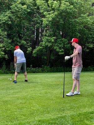 Attorney Ryan Muir waits for his colleague John Foss to tee off at a charity golf tournament benefitting Special Olympics. 