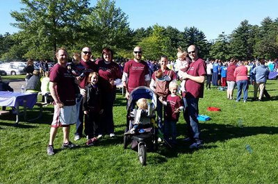 Personal injury attorneys Russell and Adam Nicolet pose with friends and family at an outdoor Alzheimer s charity event. 