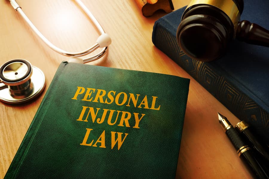 personal injury law book with gavel and stethoscope