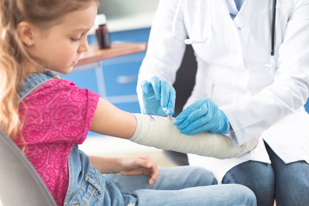 Girl having cast put on by doctor