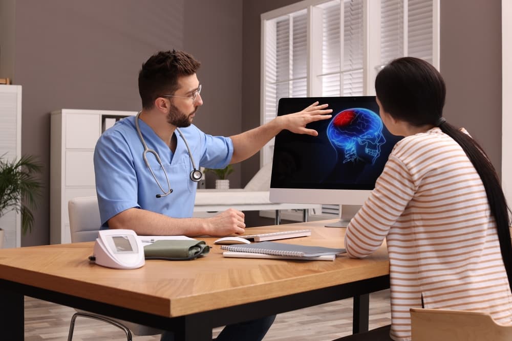 doctor showing brain injury image to person