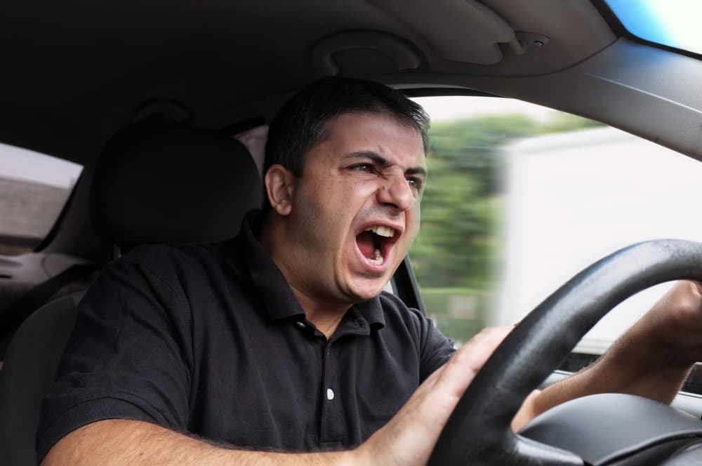 Frustrated man in a car, neglecting seat belt safety. A dangerous behavior with potential consequences on the road.