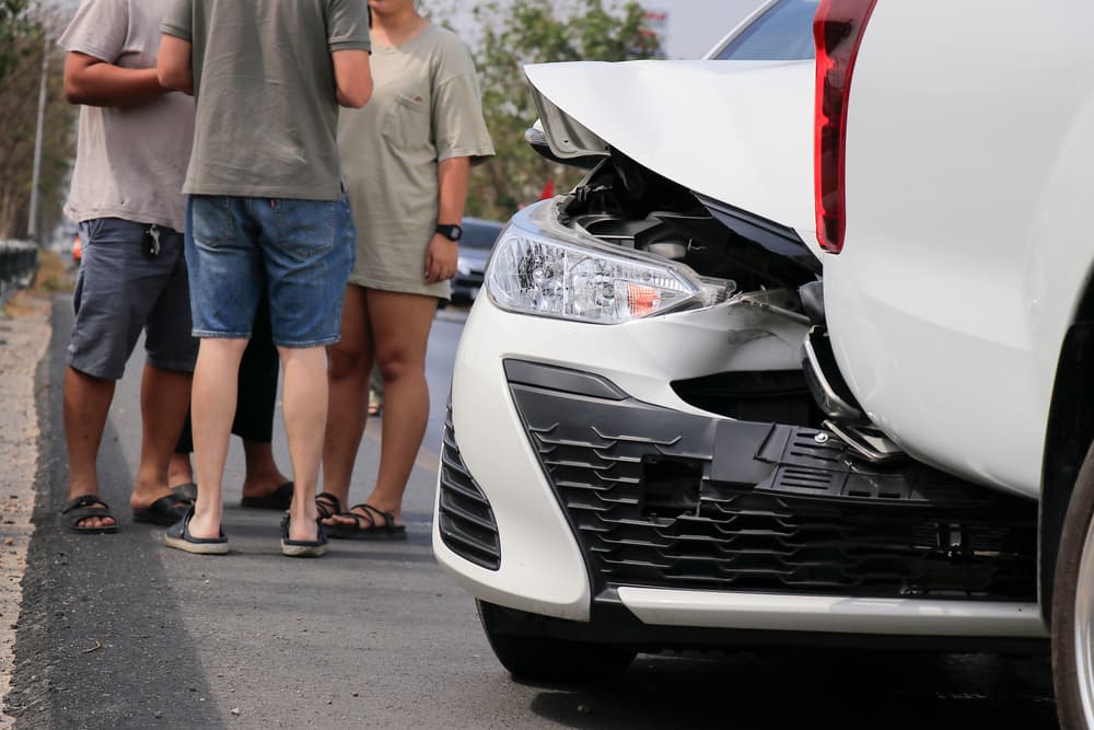 Two cars damaged in a rear-end collision, showing the front of one vehicle crashed into the back of another.