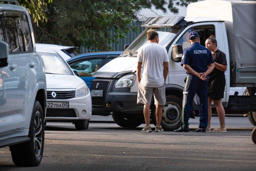 Police officer speaking with drivers at the scene of a traffic accident involving multiple vehicles, including a truck and cars. Police officer speaking with drivers at the scene of a traffic accident involving multiple vehicles, including a truck and cars.
