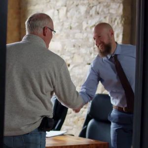 Russell Nicolet with a welcoming smile, shaking hands with a client