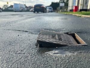A misplaced utility cover causes a trip hazard on a city sidewalk