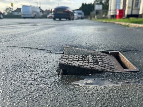 A misplaced utility cover causes a trip hazard on a city sidewalk