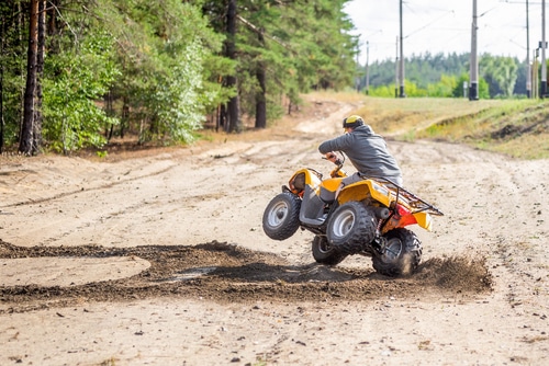 A man on ATV taking a hard turn, drifting