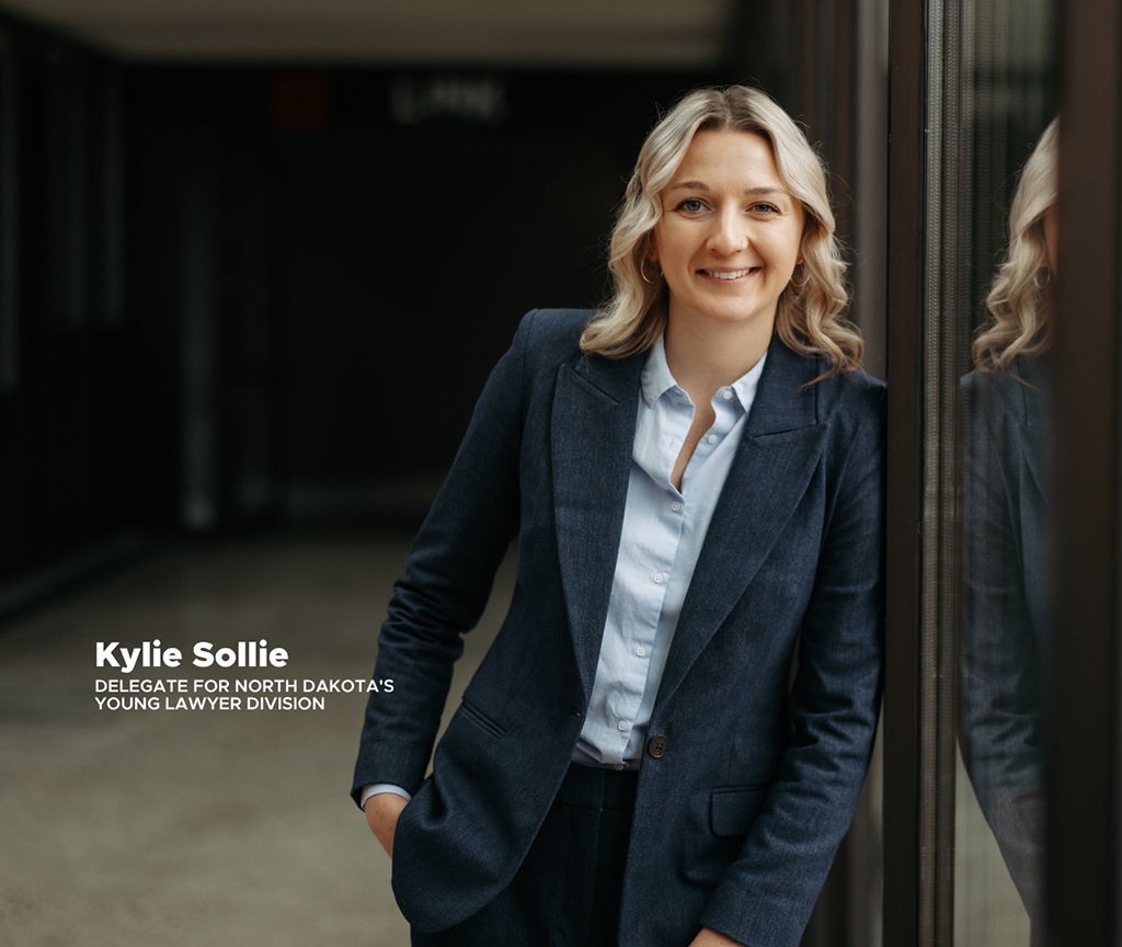 Kylie Sollie, an attorney at Nicolet Law, smiling into camera and leaning against wall.