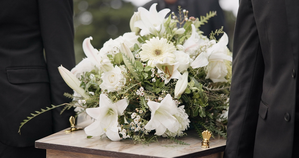 Flowers atop a casket at a funeral