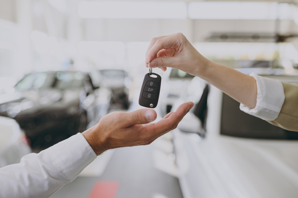 Close-up photo of hands passing off a set of car keys