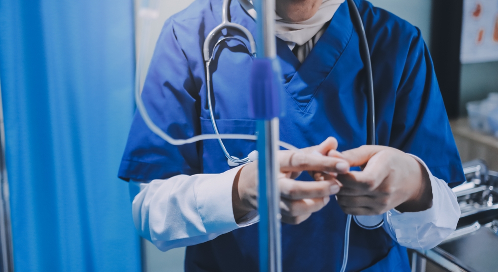 Close-up of nurse's hands administering IV treatment to patient