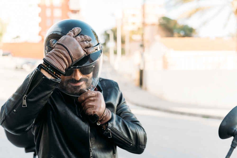Rider adjusting helmet before using motorcycle